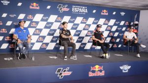 un-marchio-ai-saluti-piloti-a-piedi-team-alla-finestra-mercato-motogp-incandescente